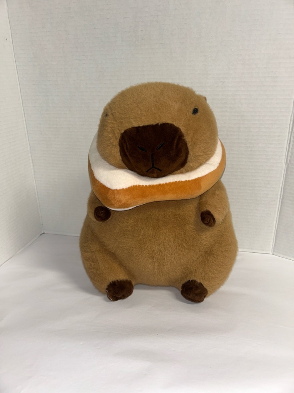 Plush Brown Capybara Pet Toy with Orange-and-White Donut Collar